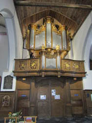 De restauratie van het beeldhouwwerk van het orgel en de balustrade van de kerk te Houtkerque (Frankrijk).